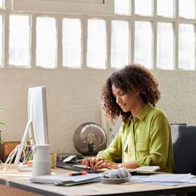 Woman working at computer in office.
